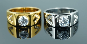 Detail of silver and gold titanium rings with inset zircon stones on reflective surface