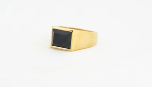 Detailansicht eines goldenen Siegelrings mit rechteckigem schwarzem Onyx-Edelstein