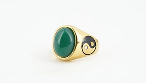 Detailed macro view of vintage gold ring featuring a green stone and Yin Yang motif