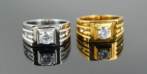 Macro detail of classic gold and silver square rings with cubic zirconia on reflective surface