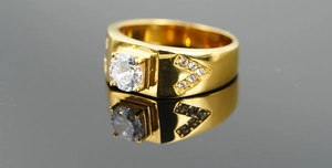 Detailed close-up of a men's gold titanium ring with a round zircon and V-set diamonds