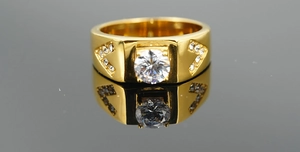 Detailed view of men's gold titanium ring with a square face and V-shaped crystal accents