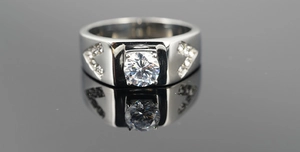 Macro shot of silver men's titanium ring with large round-cut zircon and V-shaped side stones