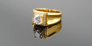 Vue macro d'une bague pour homme en plaqué or avec un grand zircon et sertissage halo