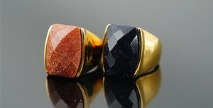 Macro detail of vintage gold rings with sparkling blue and brown sandstone square gemstones
