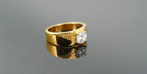 Gros plan détaillé d'une bague en acier titane doré avec zircon et gravures rayonnantes