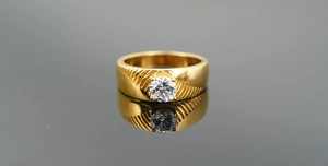 Vue détaillée bague titane doré avec texture rainurée et zircon rond taille brillant