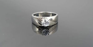 Détail d'une bague en acier titane avec pierre précieuse ronde et rainures diagonales