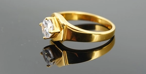 Close-up of gold plated ring featuring a round cubic zirconia in classic four-prong setting