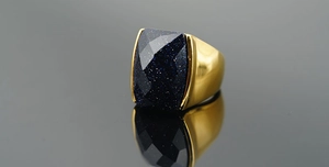 Macro shot of rectangular blue goldstone set in a gold-plated stainless steel men's ring