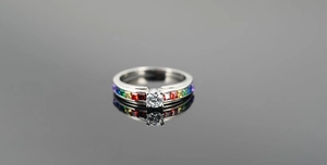 Macro shot of titanium steel ring with four-prong set diamond and rainbow gemstones