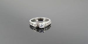 Detailed macro view of a silver titanium wedding ring with central round and side square stones