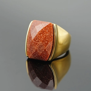 Vintage rectangle red goldstone ring with wide matte gold band on reflective background