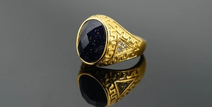 Macro shot of blue sandstone ring with gold Greek key pattern and cubic zirconia