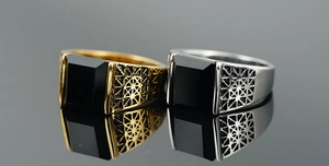 Detailed macro of vintage men's titanium rings with black gemstone and grid pattern