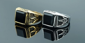Macro detail of gold and silver Freemason rings with black square faceted onyx stone