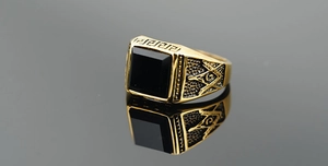 Macro view of gold Freemasonry ring featuring a black square stone and Greek Key pattern