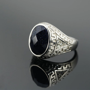 Vintage steel ring with oval blue sandstone and geometric star patterns on a grey base