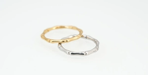 Detail of bamboo joint pattern on gold and silver stainless steel rings for men