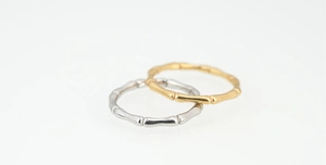 Detail view of bamboo joint rings in polished gold and silver finishes for couples