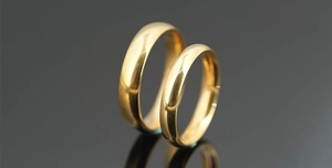 Close-up of polished gold couple rings with mirror finish and elegant reflections