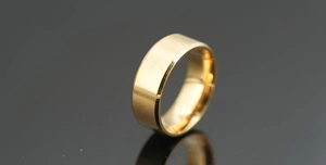 Détail d'une bague en titane doré avec bords polis et finition mate brossée élégante