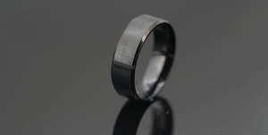 Détail d'une bague en titane noir mat brossé avec des bords biseautés polis