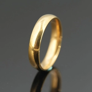 Polished gold titanium steel minimalist band ring for men and women on dark reflection