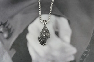 Vue macro d'un pendentif coquillage rétro avec texture vintage sur une chaîne carrée