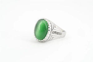 Détail d'une bague vintage argentée avec pierre œil-de-chat verte et zircons brillants