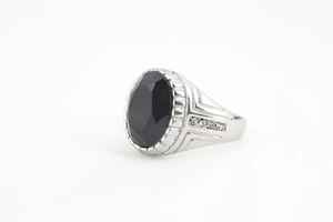 Détail d'une bague homme argent avec pierre noire ovale et bordure dentelée