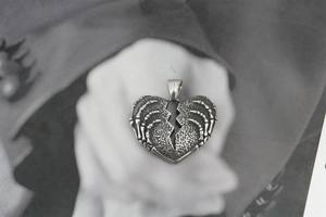 Gros plan du pendentif cœur tête de mort rétro avec une finition oxydée vintage