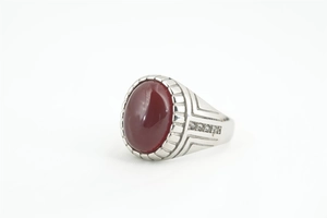 Vue détaillée d'une bague pour homme avec pierre ovale rubis et zircons sur le côté