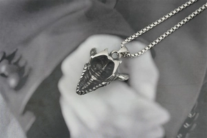 Close-up of retro titanium steel necklace with detailed hexagram monster skull pendant