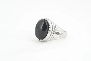 Vue détaillée d'une bague en argent avec onyx noir ovale et pierres latérales blanches