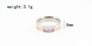 Macro shot of silver and rose gold steel ring with purple stones and love engraving