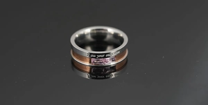 Detail of two-tone steel ring with pink rectangular gems and romantic love engraving