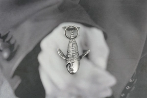 Gros plan détaillé du pendentif baleine rétro en argent avec gravure de masque d'art