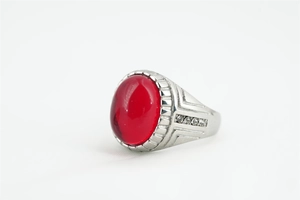 Vue macro d'une bague argentée avec grand cabochon rouge et cristaux étincelants