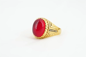 Vue détaillée d'une bague dorée avec pierre ovale rouge et zircons latéraux