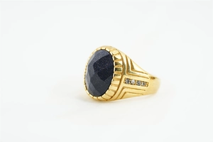 Détail macro d'une bague pour homme en or avec grès bleu ovale et effets étoilés