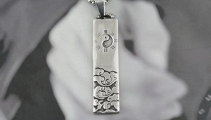 Macro shot of rectangular titanium steel pendant featuring Tai Chi and Bagua symbols