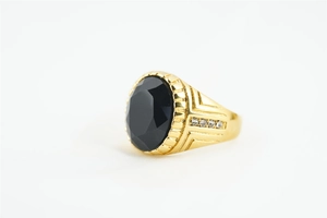 Vue détaillée d'une bague dorée avec pierre noire ovale facettée et cristaux latéraux