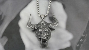 Close-up of retro silver bull head pendant with intricate textures and box chain