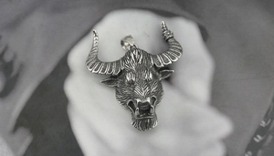 Macro detail of gothic bull head pendant with retro texture and vintage metallic finish
