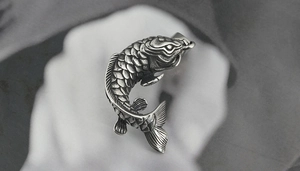 Vue détaillée d'un pendentif carpe koi en argent vintage avec texture 3D ciselée