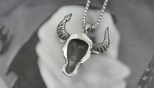 Macro view of bull skull pendant back side with hollow structure and steel box chain