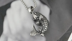 Détail macro d'un pendentif carpe koi en titane argenté avec des écailles très ciselées