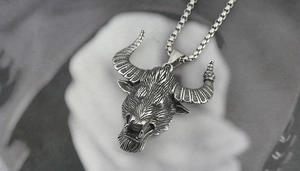 Detail of bull head pendant on silver chain with vintage distressed finish and textures