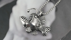 Macro close-up of retro titanium steel anglerfish pendant with vintage metallic texture